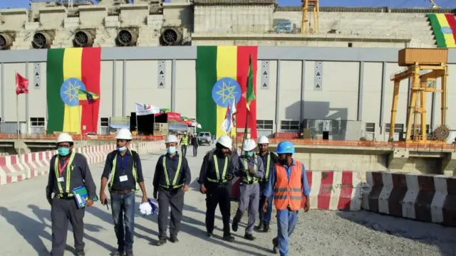 د ایتوپیا کارګرانو یوه ډله چې نارنجي لوړ کیفیت لرونکي کاري جامې یې اغوستې دي.