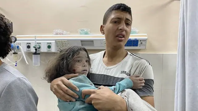 Una niña herida en brazos de un familiar en el hospital