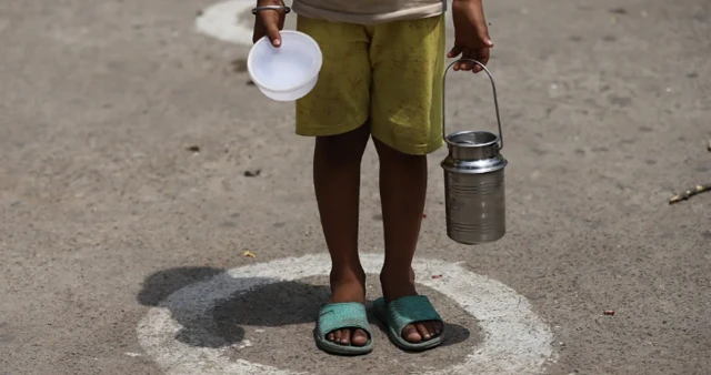 一名孩子提着着胶碗和水瓶