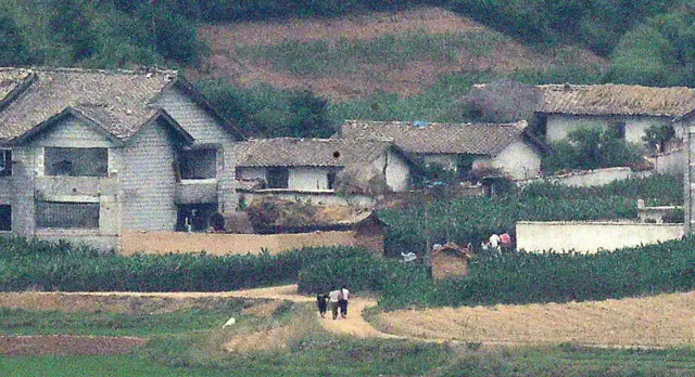 경기도 파주시 오두산 통일전망대에서 바라본 북한 황해북도 개풍군 마을에 주민들이 지나가고 있다