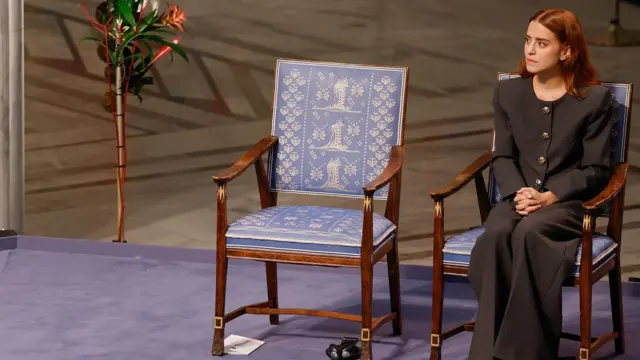 Ana Corina Sosa Machado, sentada al lado de una silla vacía, durante la ceremonia de entrega del Premio Nobel de la Paz. 