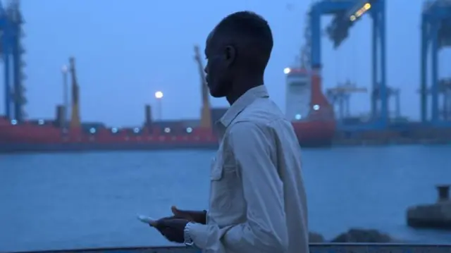 Mohamed Suleiman, téléphone à la main, regarde l'eau à Port-Soudan.