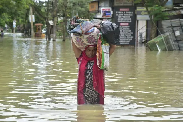 પોતાની ઘરવખરી બચાવીને લઈ જતાં એક મહિલા