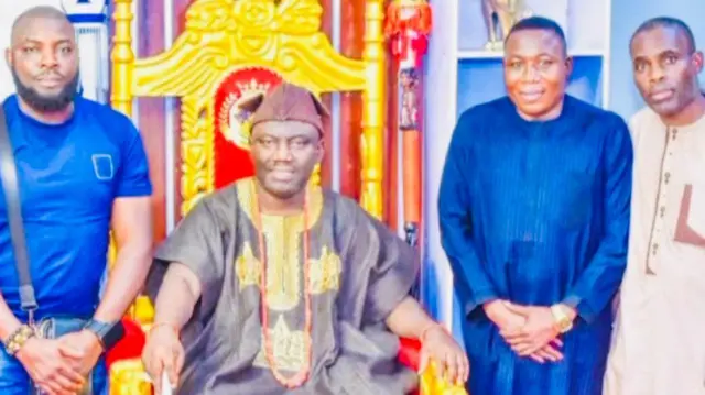 Alaafin tilu Oyo, ọba Abimbola Owoade to wọ aṣọ agbada àti fìlà aláwọ̀ eérú, fi ìlẹ̀kẹ̀ sọrun, ó mú ọ̀pá lọwọ, jókòó sórí ìtẹ́, Sunday Igboho, to wọ aṣọ aláwọ̀ búlúù dúró ní apá ọ̀tún Alaafin, tí èèyàn méjì míì sì dúró ní apá ọ̀tún àti apá òsì Kabiyesi.