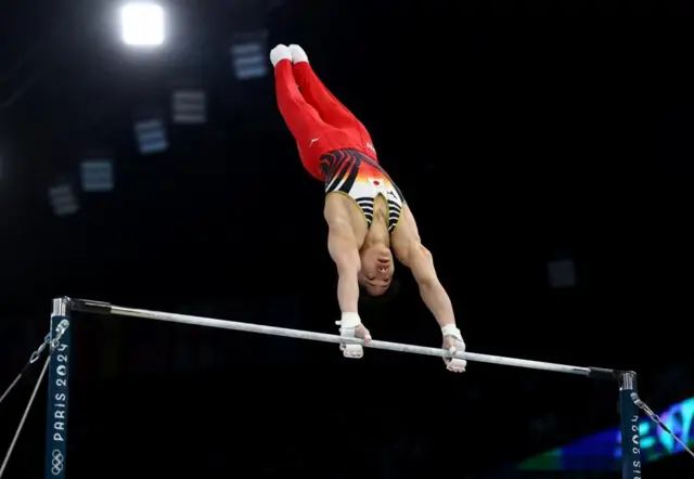 鉄棒で演技する岡