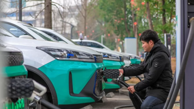Homem acrregando carro elétrico