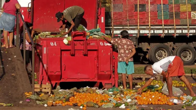 Люди копаются в отбросах овощей и фруктов, 4 ноября 2021 года
