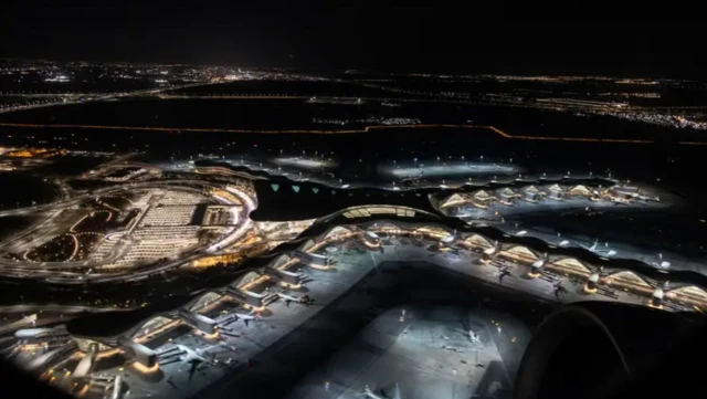 نمای هوایی از فرودگاه در شب، هواپیماها در باند هستند و چراغ‌های ساختمان‌ها روشن