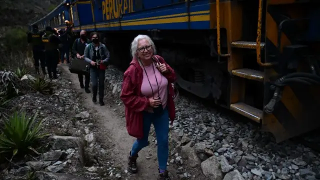Turistas caminan por la vía férrea que lleva a Macchu Pichu.