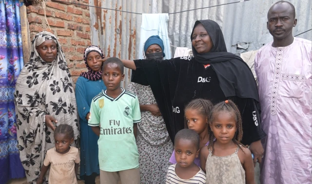 Amira, la refugiée soudanaise avec d'autres refugiés soudanais avec qui elle partage sa maisonnette