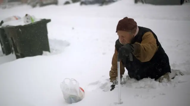 Un anciano camina entre la nieve