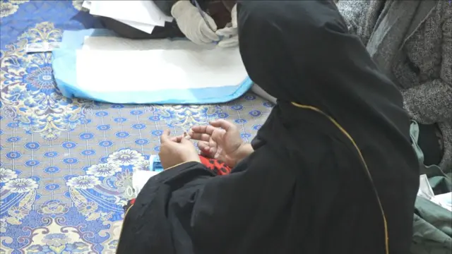 A team of outreach workers is conducting HIV tests at a brothel in Lahore