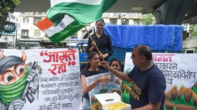 కశ్మీర్ వివాదం, స్వీట్లు పంచుకుంటున్న అమ్మాయి