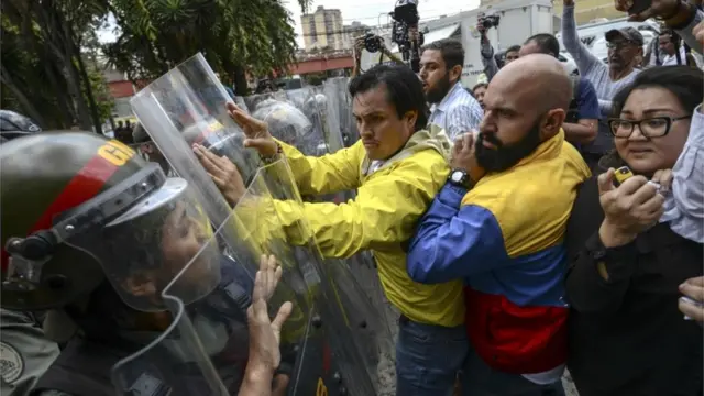 La oposición forcejea con la policía en Caracas.