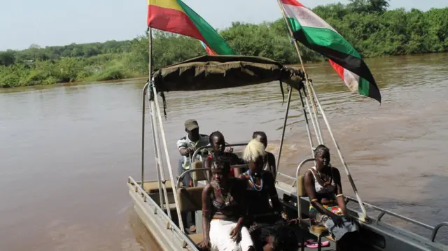 የጋምቤላ ከተማን በሚያቋርጠው ወንዝ ላይ በጀልባ የሚጓዙ ሰዎች