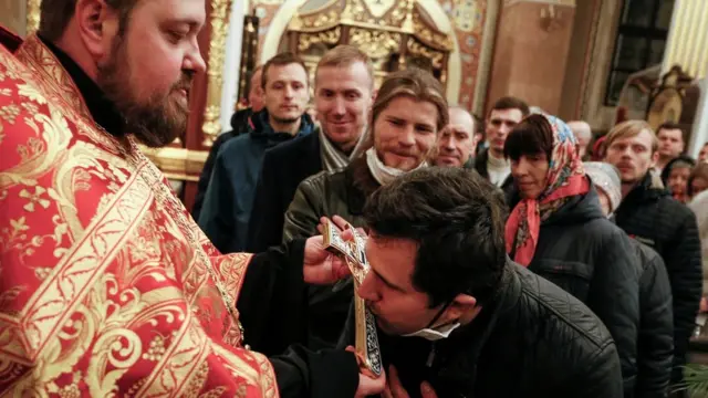 Believers queue to kiss a cross as they attend the Orthodox Easter service at the Holy Transfiguration Cathedral amid the coronavirus disease (COVID-19) outbreak in the rebel-controlled city of Donetsk, Ukraine April 19, 2020. REUTERS/Alexander Ermochenko