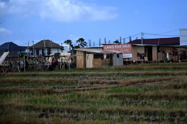 Papan bertuliskan "Tanah Dijual" terlihat dikelilingi hamparan sawah di Canggu, Kabupaten Badung, Pulau Bali, pada 22 Oktober 2024.