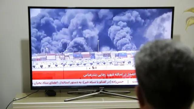 مردی در حال تماشای اخبار پس از انفجار مهیب در بندر شهید رجایی در جنوب ایران، در حالی که مقامات در حال بررسی علت انفجار در ۲۶ آوریل ۲۰۲۵ هستند.