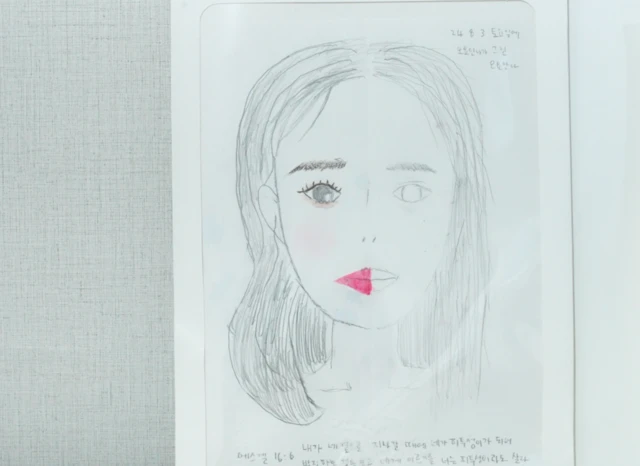 오요안나가 그린 자화상 속 그는 한쪽 얼굴에는 화장을 했고, 다른 한쪽은 공허하게 남겨 두었다.