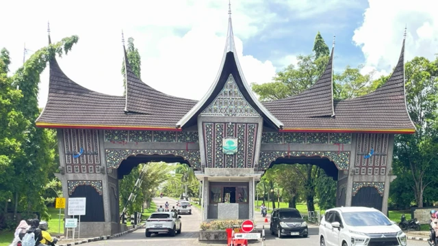 Sebuah gerbang berbentuk bangunan khas minangkabau dengan dua lorong tempat kendaraan keluar dan masuk.