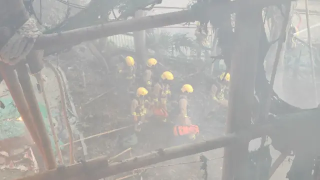 소방대원들이 중장비를 챙겨 웡 푹 코트 화재 현장에 진입하는 모습