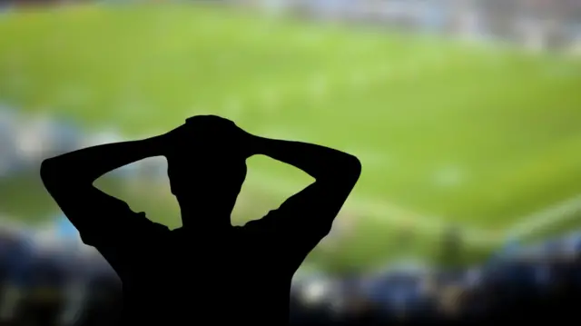 Silhueta de torcedor em estádio