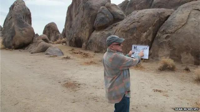 Langley looks at a photograph in Alabama Hills