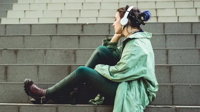 девушка, одетая в стиле гранж, сидит на ступеньках