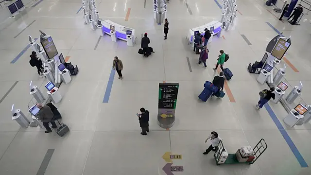 Viajeros pasan por el vestíbulo de facturación de la terminal B del Aeropuerto Internacional Logan de Boston el 2 de abril de 2020