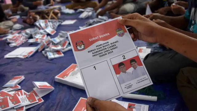 Pekerja menyortir dan melipat surat suara pemilihan bupati dan wakil bupati Ciamis di gudang logistik KPU Kabupaten Ciamis, Jawa Barat, Jumat (8/11/2024).