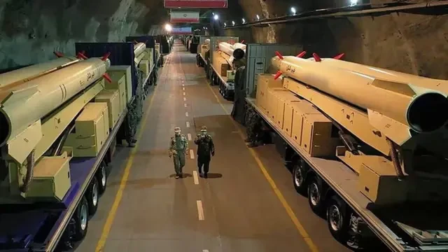 Bir tünelin içinde çok sayıda roketin arasından yürüyen iki asker