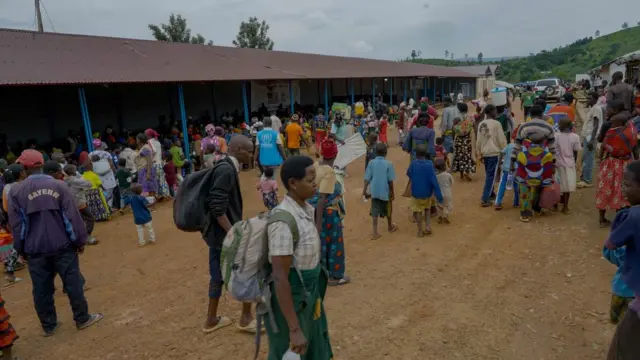 Abahungutse bari mu kibanza bashikiramwo i Nyabitare, bamwe bicaye mu gihangari barindiriramwo kwandikwa, gufotorwa no guhabwa amaterefone bazorungikrwako amafaranga y’itike n’ayo kubabeshaho