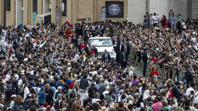 Papa Francisco em carro cercado por uma multidão de fiéis