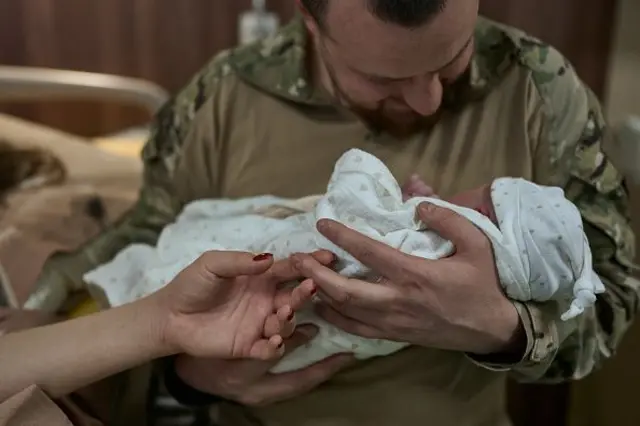 військовий тримає на руках немовля