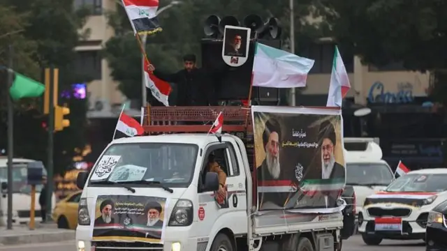 बगदाद के तहरीर स्क्वायर में ईरान समर्थक रैली के दौरान 2 अप्रैल, 2026 को अपने देश का झंडा लहराते हुए एक इराकी व्यक्ति