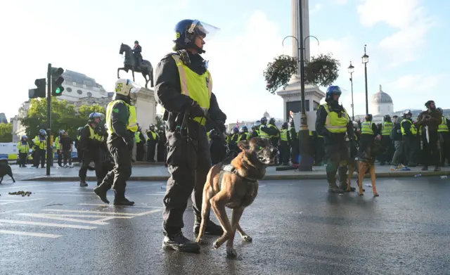 Eylül ayında düzenlenen bir Unite the Kingdom protestosu sırasında, Trafalgar Meydanı yakınındaki bir sokakta, arka planda heykeller ve müze ile birlikte, çevik kuvvet kaskı takmış bir polis memuru dururken, polis kalabalıkları da arka planda görülüyor.