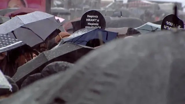 Hrant Dink anmasına katılanların şemsiyeleri ve bir döviz görülüyor. Dövizde "Hepimiz Hrant'ız, hepimiz Ermeniyiz" yazıyor. (19 Ocak 2026)