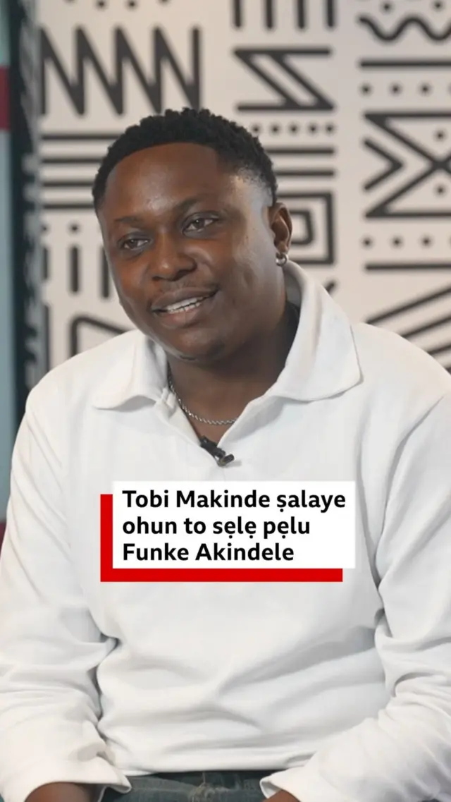 Tobi Makinde ti ọpọ mọ si Timini wọ asọ funfun, o joko sori aga kan, to n ba BBC News Yoruba sọrọ
