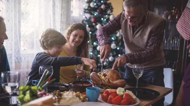 Avô corta o Peru e distribui para a família durante um almoço de Natal
