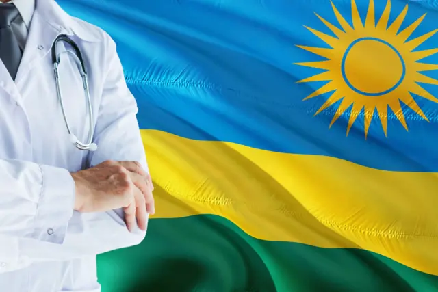 ጋዋን ዝተኸደነ ሓኪም ምስ ባንዴራ ርዋንዳ