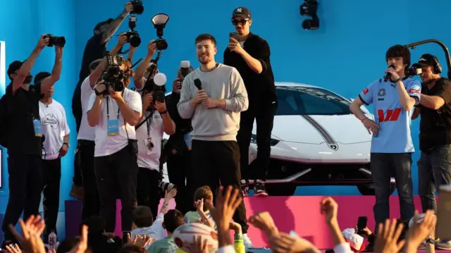 MrBeast falando com fãs em cima de um palco em Sydney.