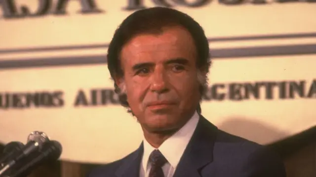 Carlos Menem, um homem bronzeadoesporte da sorte aviãozinhomeia idade com cabelos castanhos tingidos