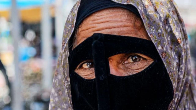 मास्क पहनी हुइ एक ईरानी बंदारी महिला