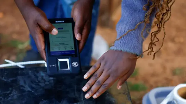 Polling agent scans box wey contain electoral materials with Biometric Voter Verification Machine (BVVM) for polling station