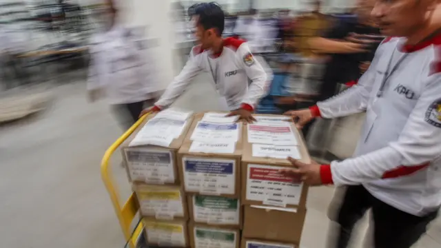 Petugas KPU membawa logistik surat suara Pemilu saat simulasi sortir, lipat dan pengepakan logistik di Kantor KPU, Kabupaten Bogor, Jawa Barat, Kamis (27/07).