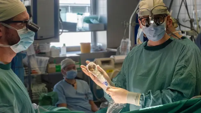 Cirurgião com aparelho na mão em meio à operação