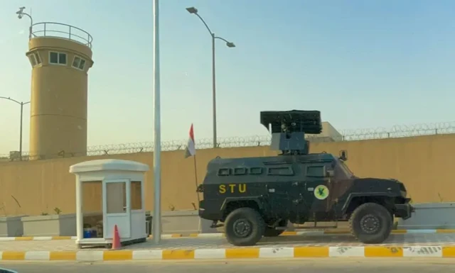 نمایی از سفارت آمریکا در بغداد، دیوار سبزرنگ و یک خودروی نظامی مقابل آن