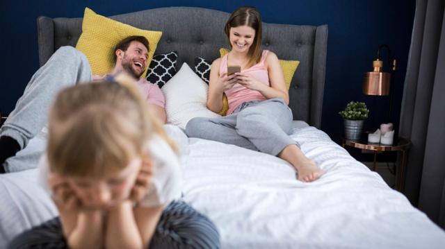 Pais mexem em celular enquanto filha está triste