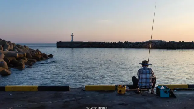 یک ماهیگیر در بندرگاهی در سئوگویپو، دومین شهر بزرگ جزیره ججو در کره جنوبی