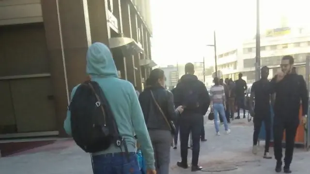Cheikh est obligé de faire la queue pour une prise de température